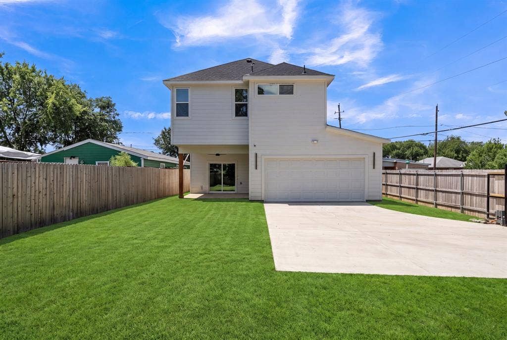 3639 Pueblo Street, Dallas, TX 75212 Two-story exterior featuring white siding, a multi-car garage, an expansive lawn, and wood-paneled privacy fencing