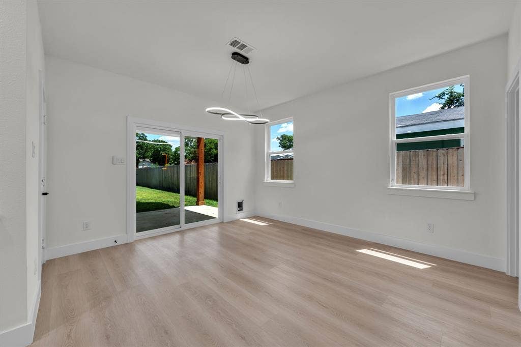 3639 Pueblo Street, Dallas, TX 75212 Interior space featuring wood-finish flooring, recessed lighting, double-pane windows, and sliding glass doors with direct access to a concrete patio