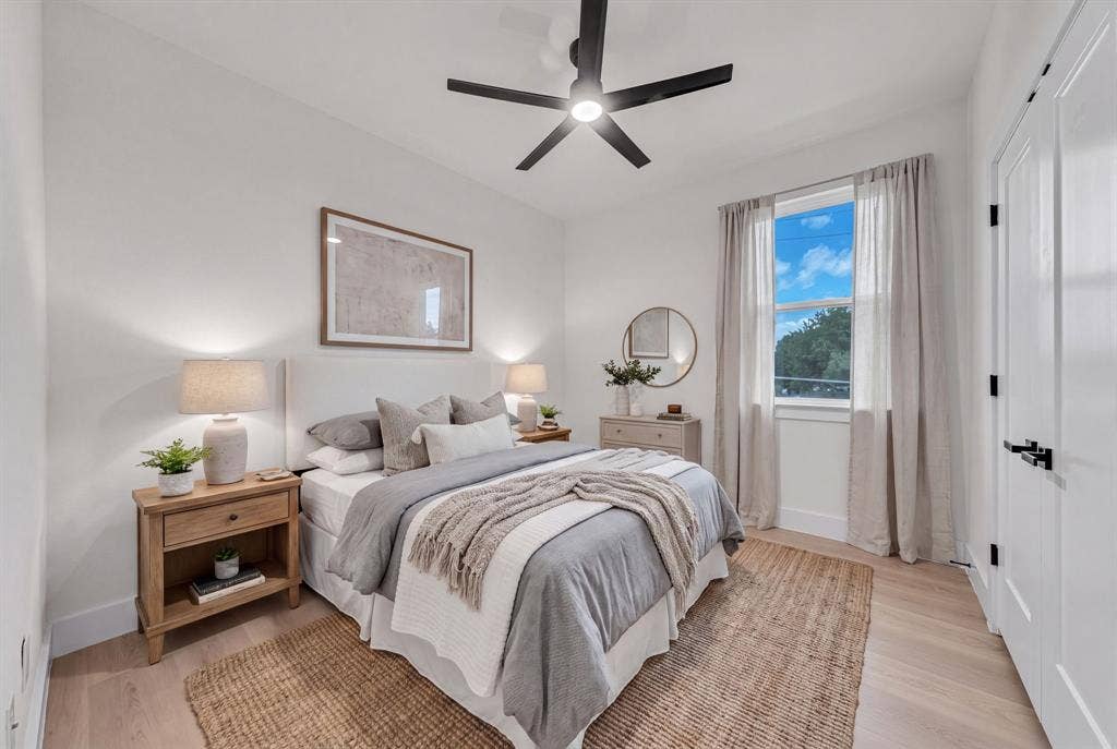 3639 Pueblo Street, Dallas, TX 75212 Neutral-toned interior featuring wood-finish flooring, a matte black multi-blade ceiling fan, and a single-hung window with black hardware accents