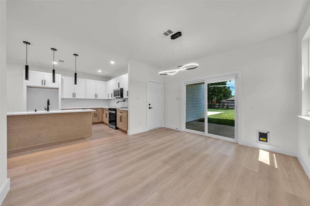 3639 Pueblo Street, Dallas, TX 75212 Kitchen featuring white upper cabinetry, wood-finish lower cabinetry, quartz countertops with a stone backsplash, matte black hardware, and wood-finish flooring