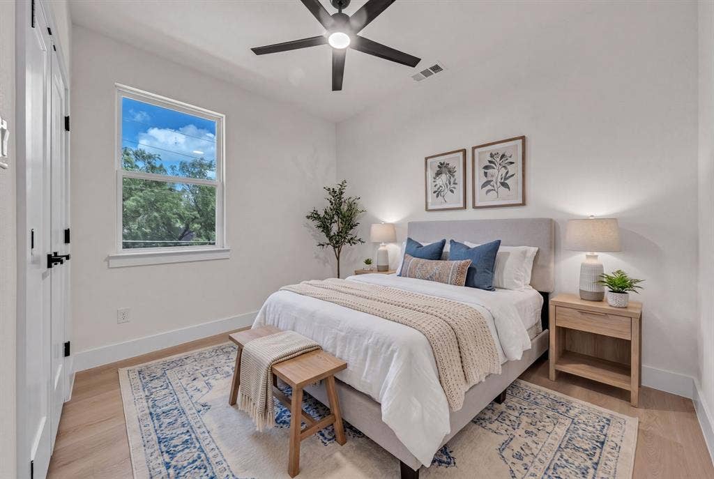 3639 Pueblo Street, Dallas, TX 75212 Neutral-toned room featuring wood-finish flooring, a contemporary matte black ceiling fan, and double closet doors with matching black hardware