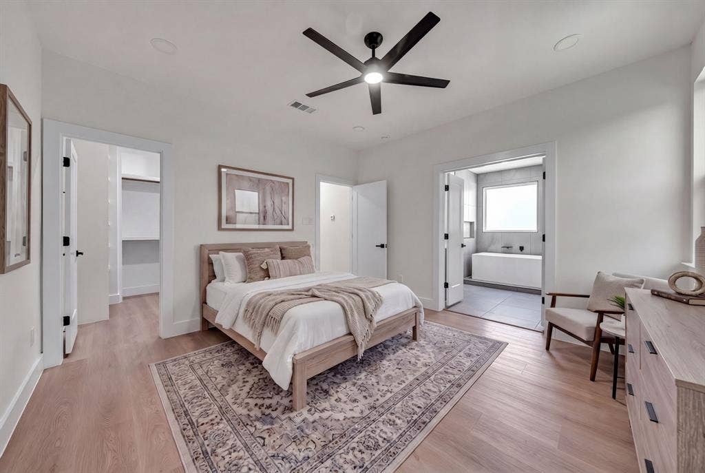 3639 Pueblo Street, Dallas, TX 75212 Neutral-toned bedroom featuring wood-finish flooring, a matte black multi-blade ceiling fan, recessed lighting, and a walk-in closet
