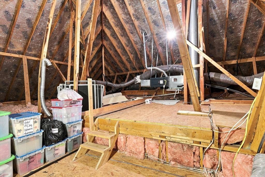 Attic space featuring plywood flooring for ample storage.