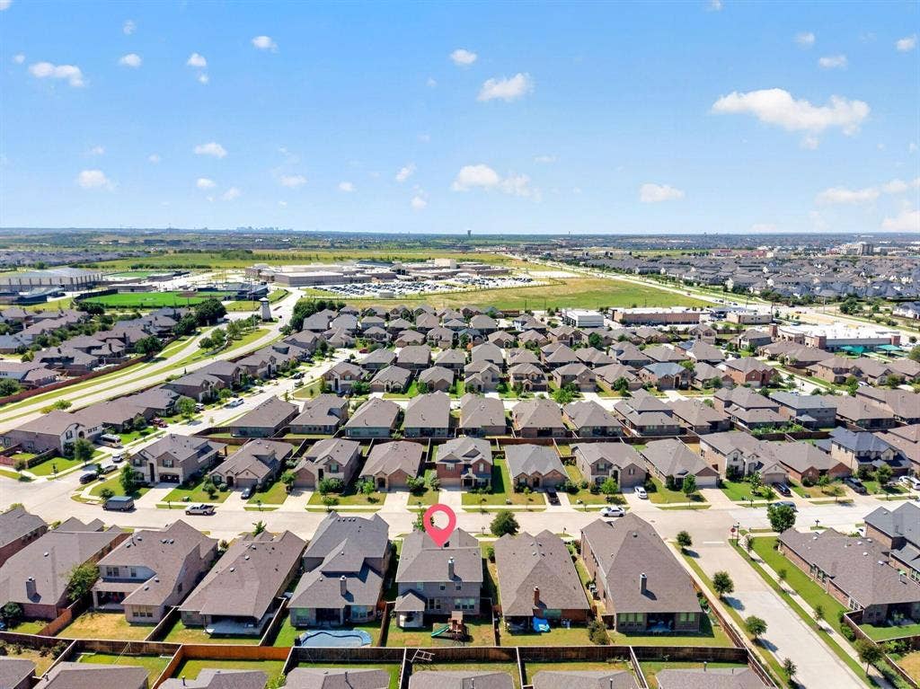 Aerial perspective of a multi-story residential property featuring a shingle roof, chimney, and enclosed rear yard