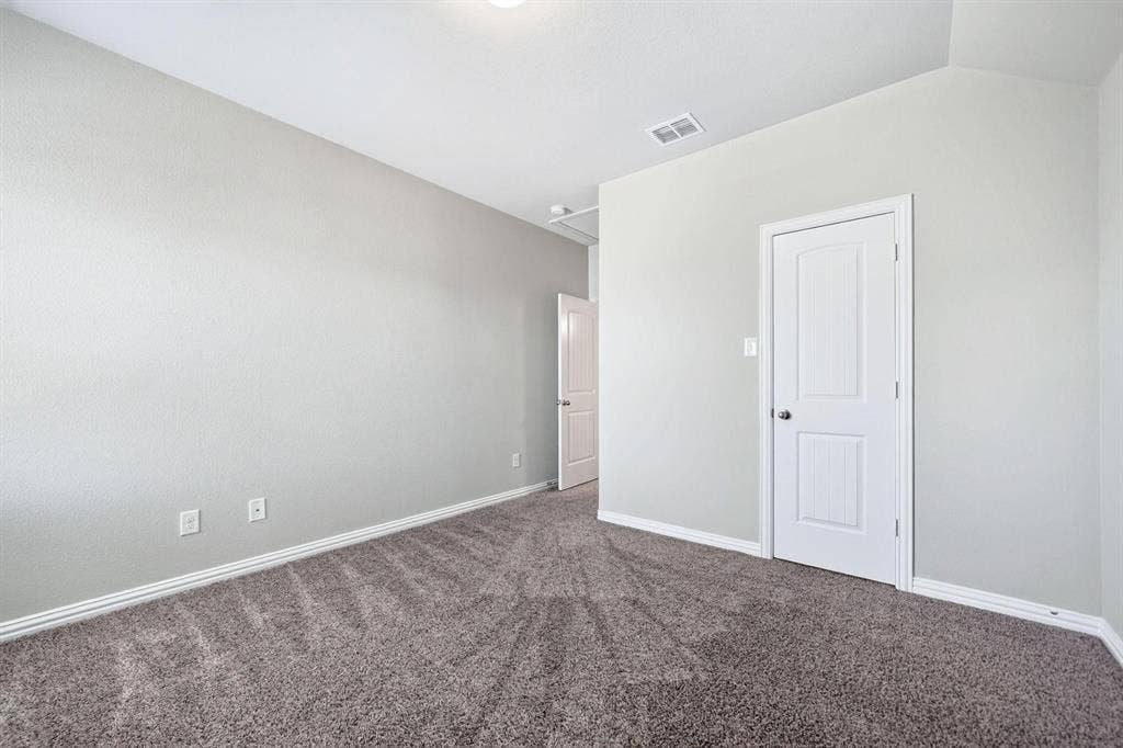 Neutral wall palette featuring textured finishes, wall-to-wall carpeting, and white interior paneled doors