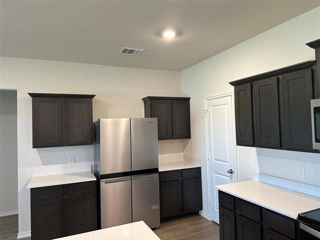 219 Greenshade, Caddo Mills, TX 75135 Kitchen featuring appliances with stainless steel finishes, dark wood-style floors, and light stone countertops