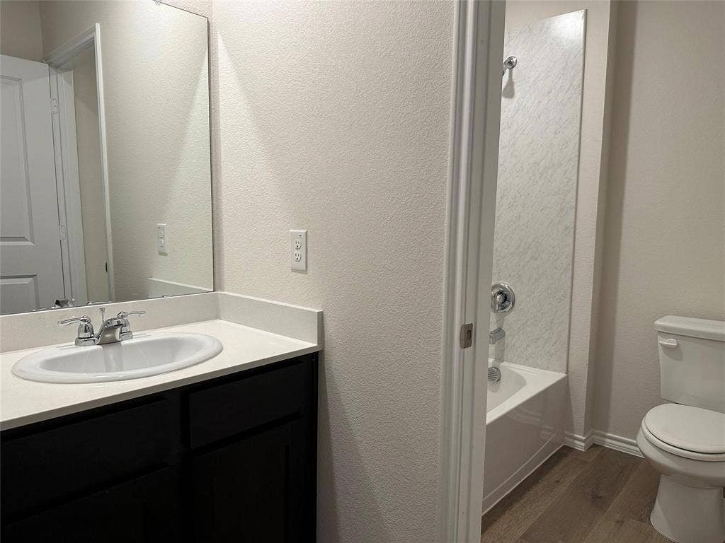 219 Greenshade, Caddo Mills, TX 75135 Bathroom with dark wood-style flooring, vanity, and shower / washtub combination