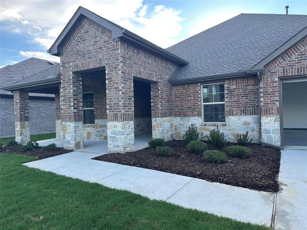 219 Greenshade, Caddo Mills, TX 75135 View of front facade with a shingled roof, brick siding, a front lawn, and stone siding