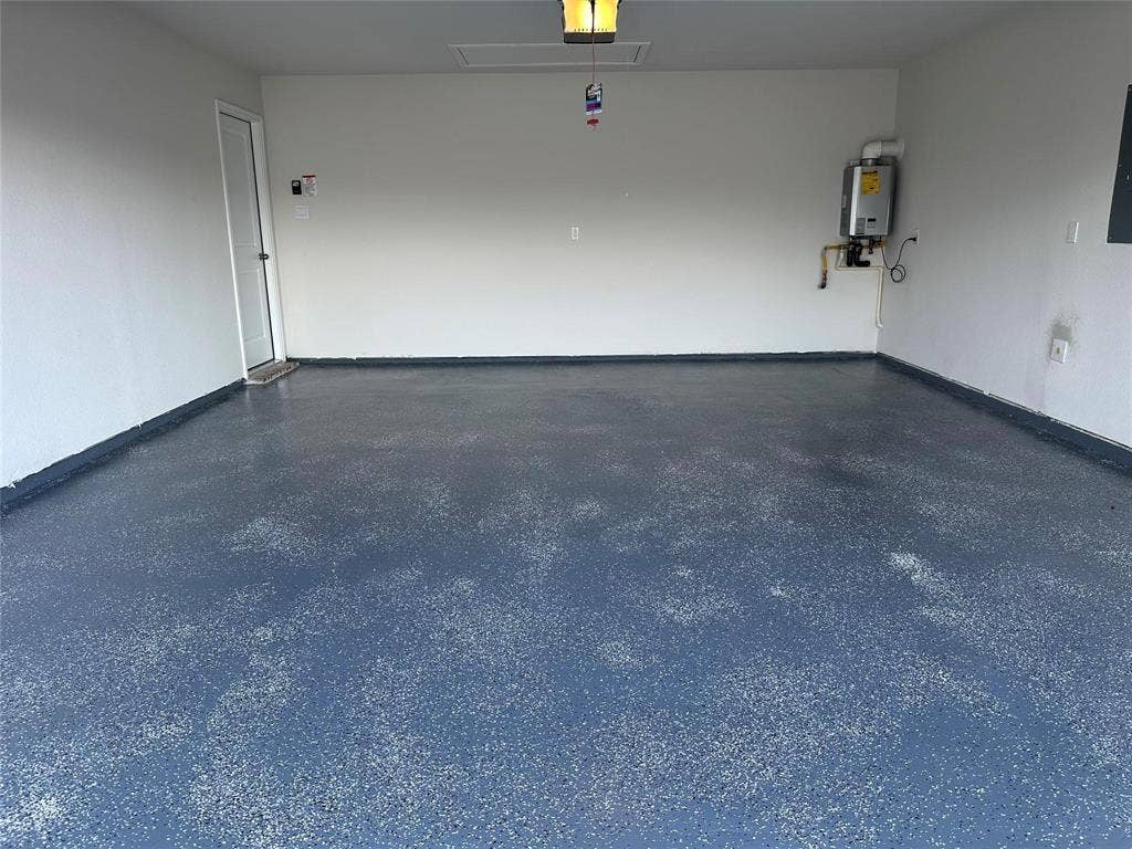219 Greenshade, Caddo Mills, TX 75135 Garage with a garage door opener, tankless water heater, and electric panel