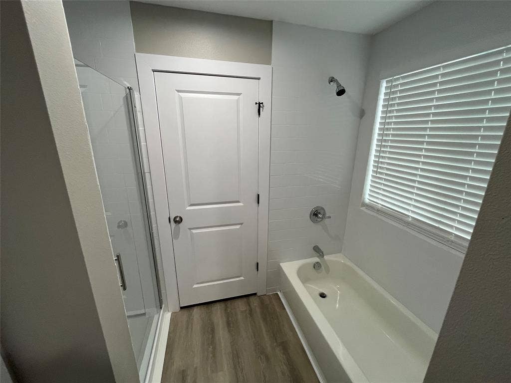 1104 Wake Drive, Richardson, TX 75081 Bathroom featuring a glass-enclosed shower, integrated soaking tub with chrome fixtures, subway tile surround, and wood-finish flooring