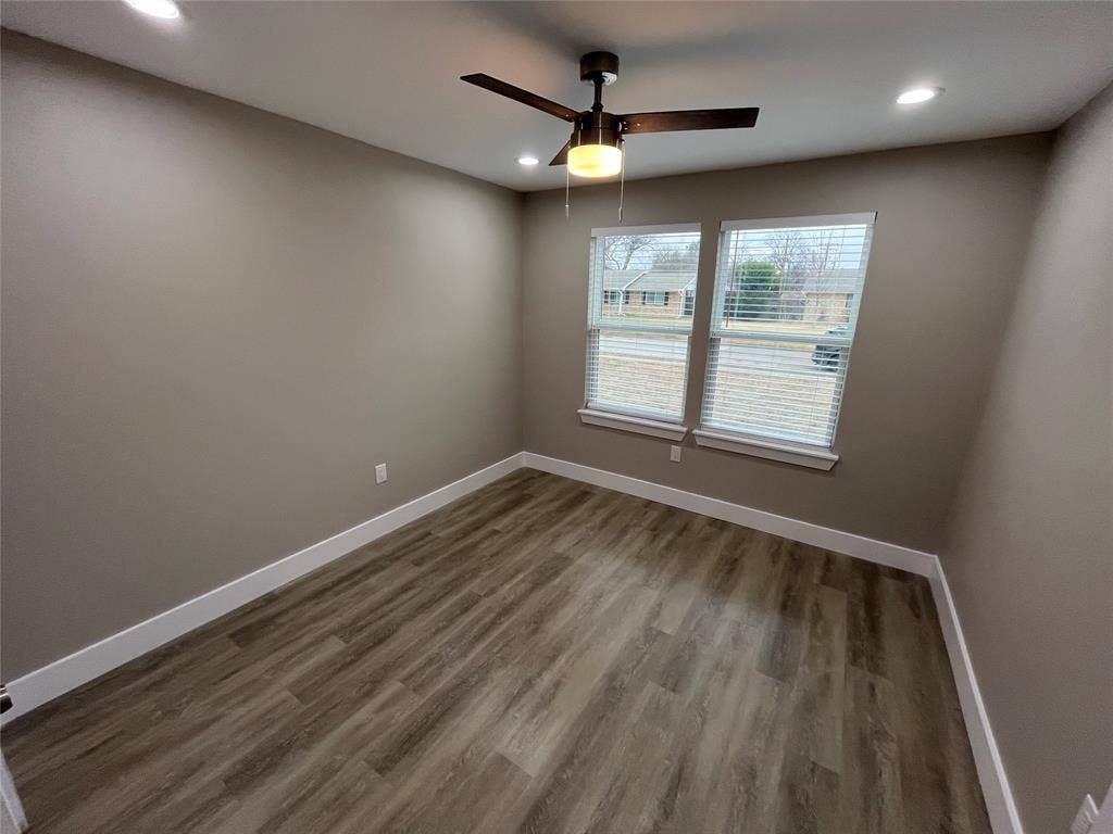 1104 Wake Drive, Richardson, TX 75081 Neutral-toned room featuring wood-finish flooring, recessed lighting, double-pane windows with horizontal blinds, and a central ceiling fan with an integrated light fixture
