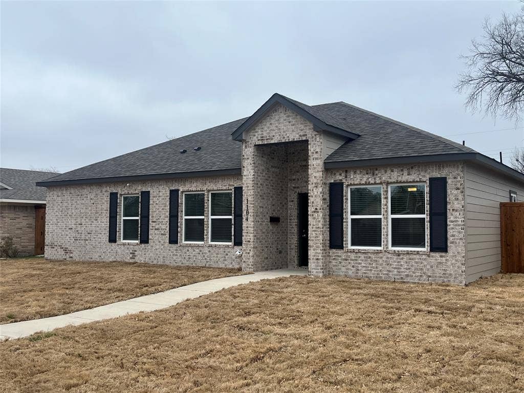 1104 Wake Drive, Richardson, TX 75081 Single-story brick exterior featuring a covered entryway, decorative window shutters, and a hipped roofline