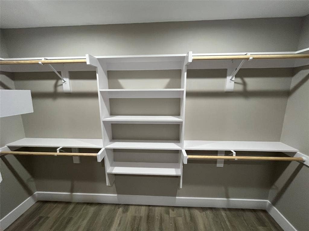 1104 Wake Drive, Richardson, TX 75081 Walk-in closet featuring white built-in shelving, multi-level clothing rods, and wood-finish flooring