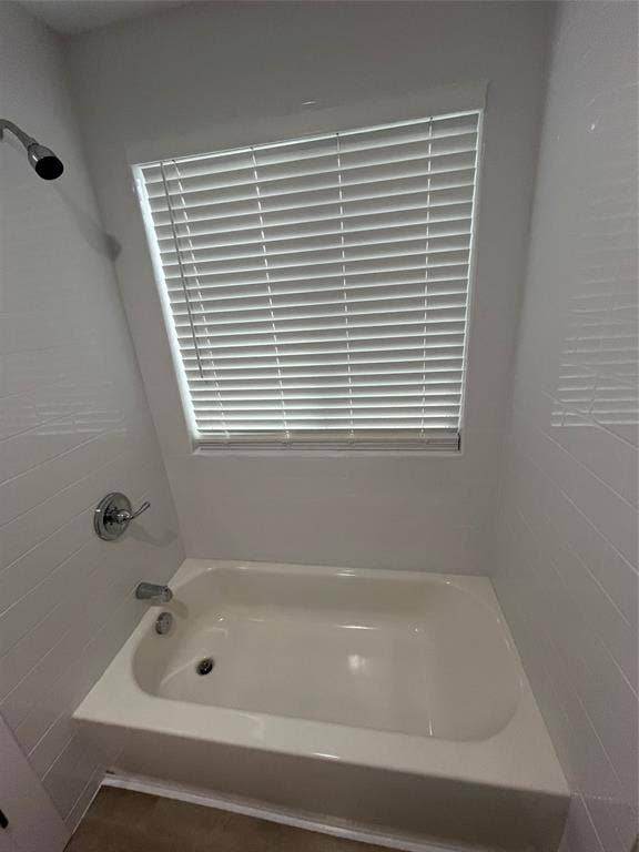 1104 Wake Drive, Richardson, TX 75081 Bathtub surround featuring white wall tiling, polished chrome fixtures, and a recessed window with horizontal blinds