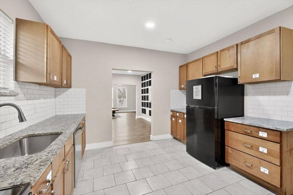 812 Centre Street, Dallas, TX 75208 Kitchen featuring light wood cabinetry, stone-surface countertops, white subway tile backsplash, and ceramic tile flooring