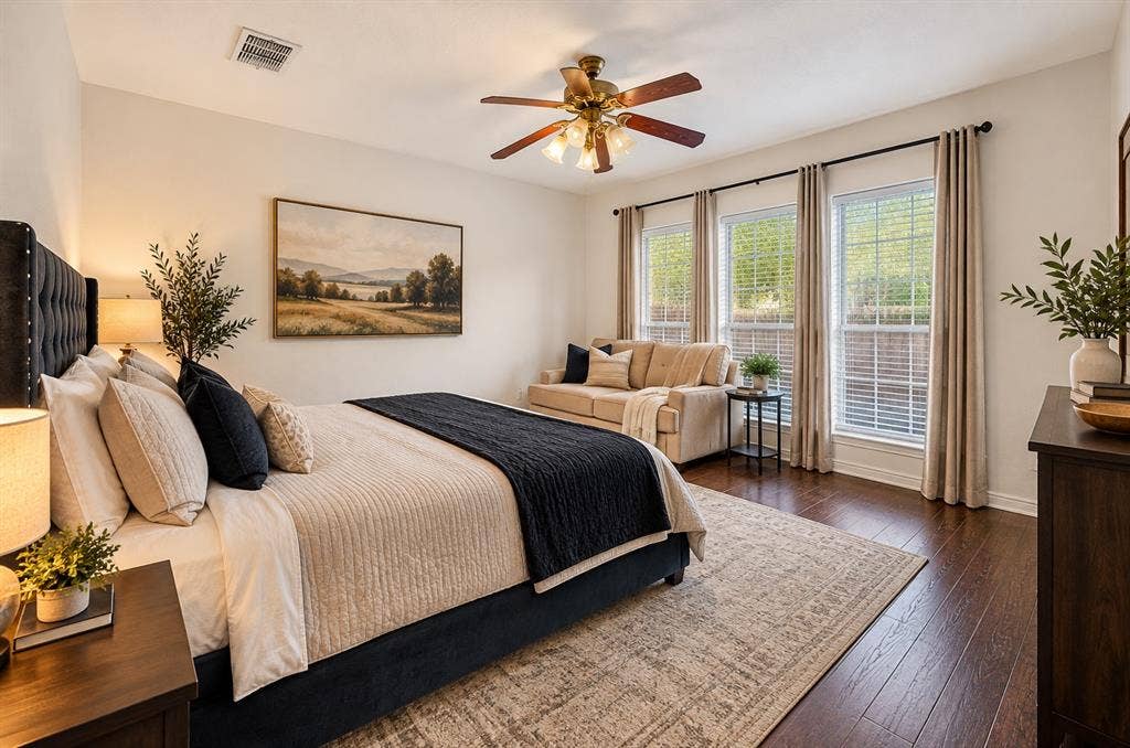 Spacious room featuring dark-toned wood-finish flooring, a multi-blade ceiling fan with integrated lighting, and three tall windows