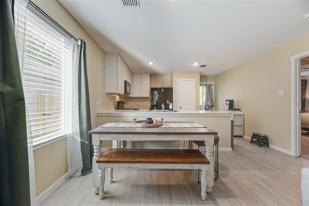 6742 Highlands Street, Princeton, TX 75407 Kitchen featuring white cabinetry, solid-surface countertops, recessed lighting, and wood-finish flooring