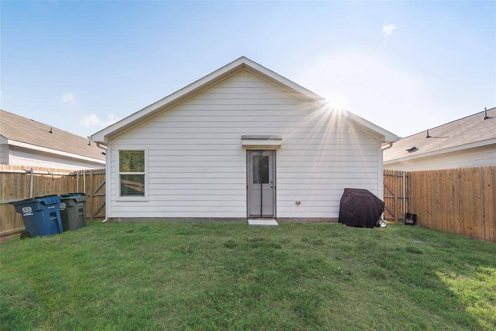 6742 Highlands Street, Princeton, TX 75407 Rear exterior featuring horizontal lap siding, a single-door entrance, and a fenced backyard