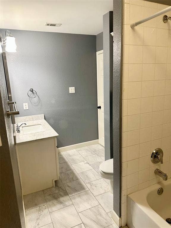 4327 Chasemoor Place, Frisco, TX 75035 Bathroom featuring stone-finish countertop with integrated sink, vanity cabinet, tile flooring, and tiled shower enclosure with metal fixtures