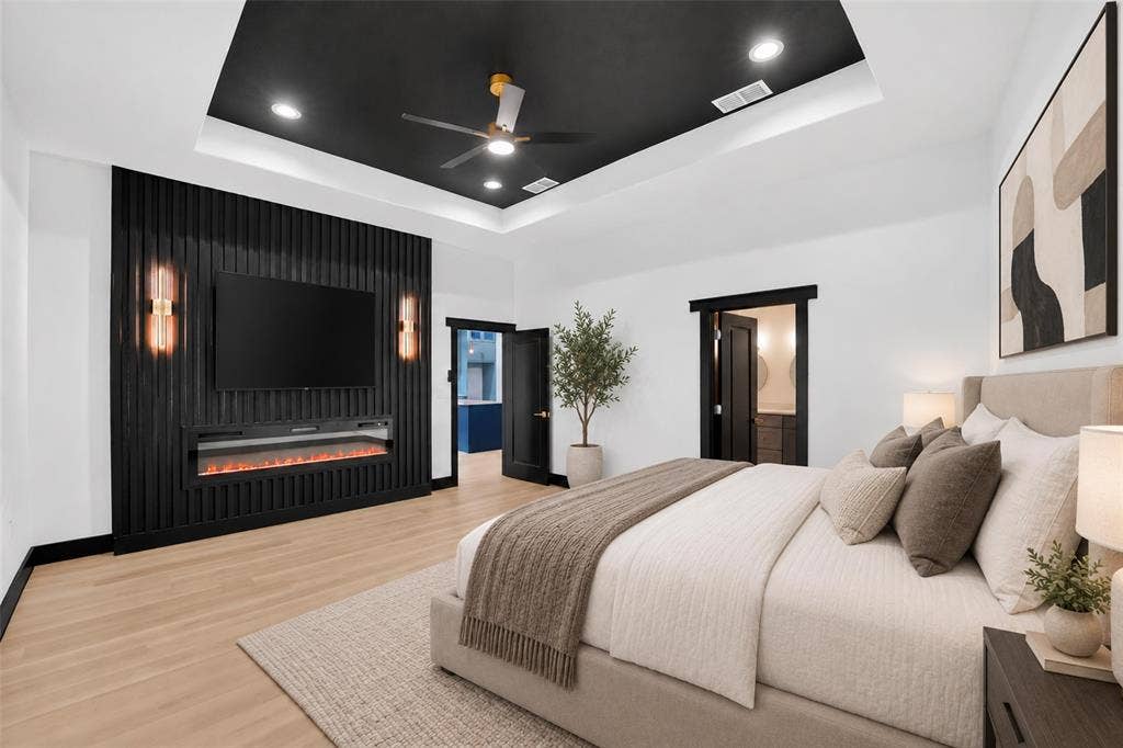 601 Melody Circle, Kaufman, TX 75142 Tray ceiling with a black finish, recessed lighting, black slatted wood accent wall, built-in electric fireplace, and wood-finish flooring