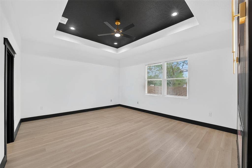 601 Melody Circle, Kaufman, TX 75142 Tray ceiling featuring a contrasting black finish, light wood-finish flooring, and recessed lighting