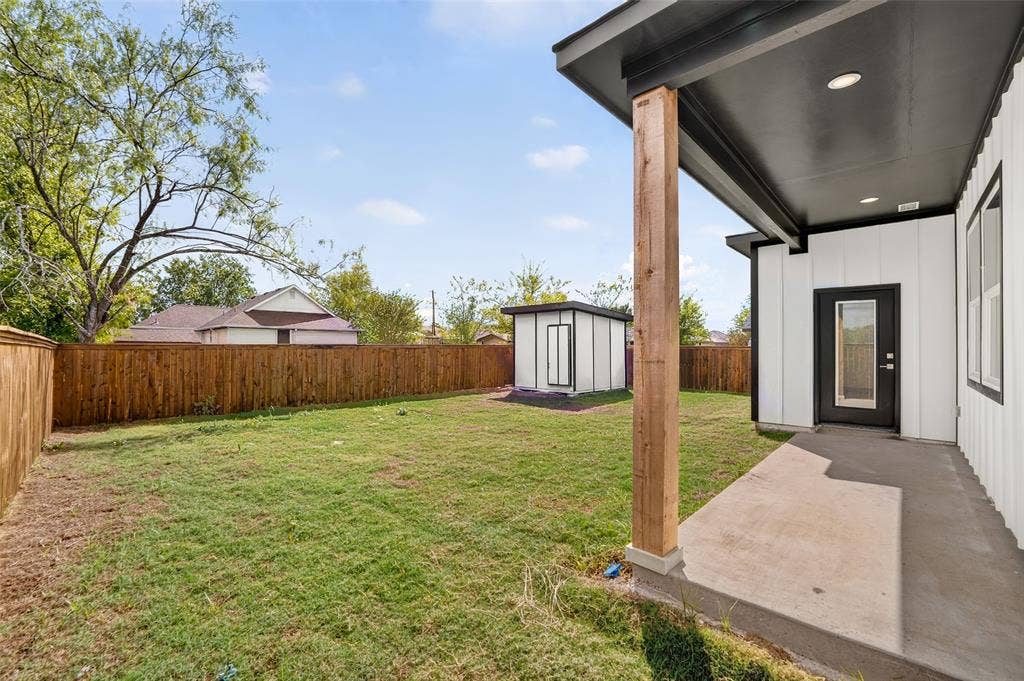 601 Melody Circle, Kaufman, TX 75142 Backyard featuring a concrete patio, a covered porch with a wood-finish post, a detached storage shed, and perimeter wood fencing