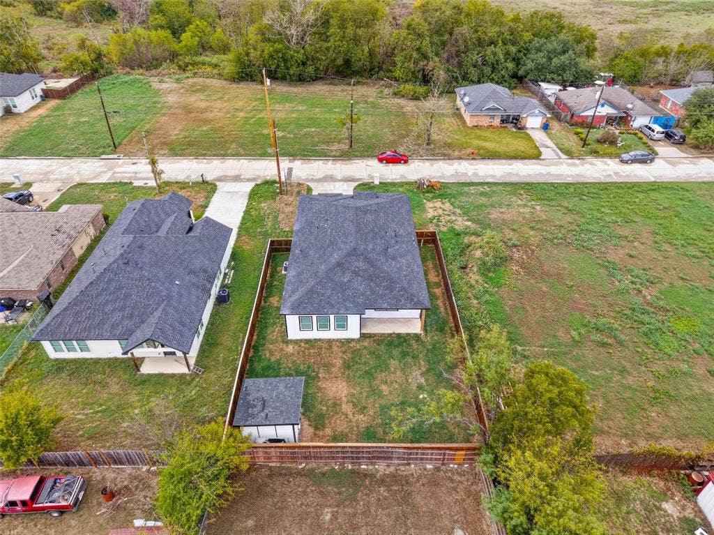 601 Melody Circle, Kaufman, TX 75142 Aerial perspective of a detached single-story residence featuring a shingled roof, exterior siding, a fenced rear yard, and a detached outbuilding