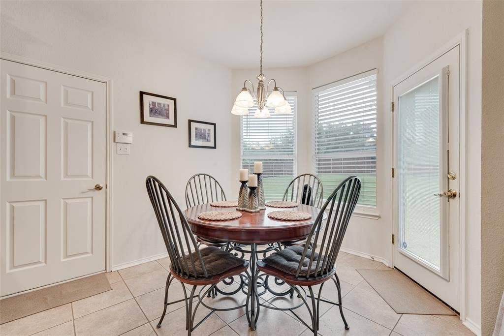 148 Oakbluff Drive, Murphy, TX 75094 Breakfast nook featuring neutral tile flooring, a multi-light chandelier, bay windows, and a glass-paneled exterior door