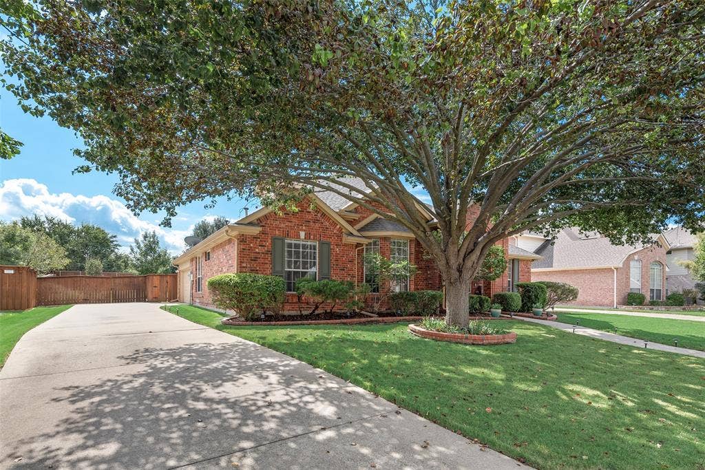 148 Oakbluff Drive, Murphy, TX 75094 Brick exterior facade featuring a multi-gabled roofline, concrete driveway, front yard landscaping, and mature canopy tree