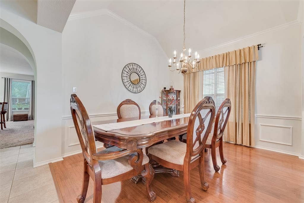 148 Oakbluff Drive, Murphy, TX 75094 Dining area featuring vaulted ceilings, wood-finish flooring, decorative wall molding, and a multi-arm chandelier