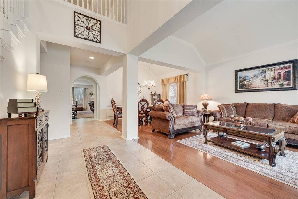 148 Oakbluff Drive, Murphy, TX 75094 Open-concept interior featuring vaulted ceilings, neutral tile flooring, wood-finish flooring, and arched doorways