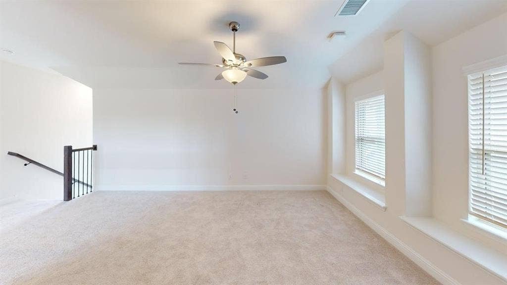 333 Elk Drive, Fate, TX 75189 Neutral-toned interior space featuring recessed ceiling lighting, a central brushed-nickel ceiling fan with integrated light fixture, carpeted flooring, and built-in window seating with horizontal blinds