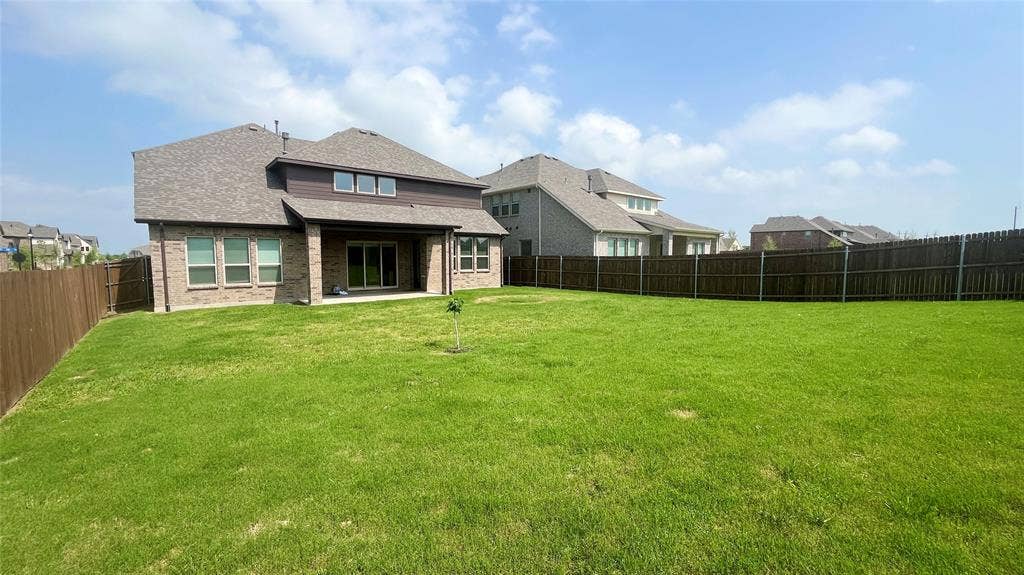 333 Elk Drive, Fate, TX 75189 Spacious backyard with a grass lawn, covered patio, masonry exterior, and perimeter wood fencing