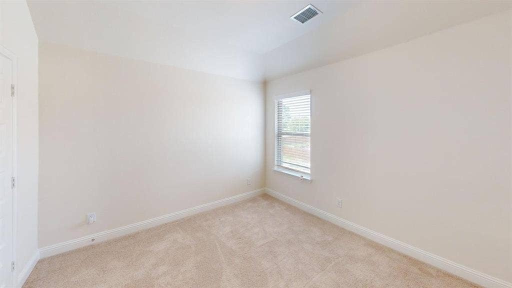 333 Elk Drive, Fate, TX 75189 Neutral-toned interior space featuring neutral wall-to-wall carpeting, high tray ceilings, and a window with horizontal blinds