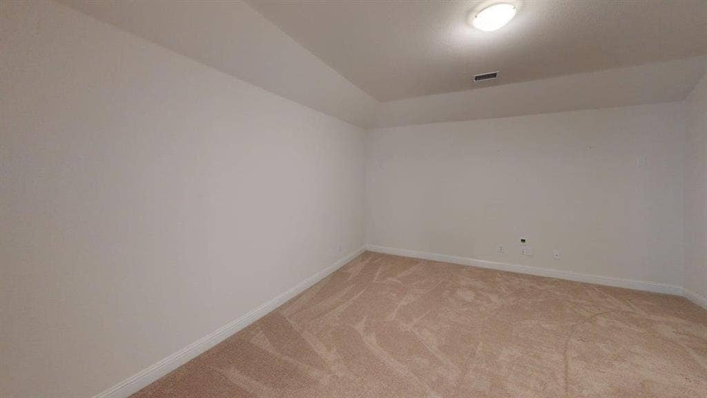 333 Elk Drive, Fate, TX 75189 Interior room featuring neutral-toned carpeting, high tray ceilings, and an overhead flush-mount light fixture