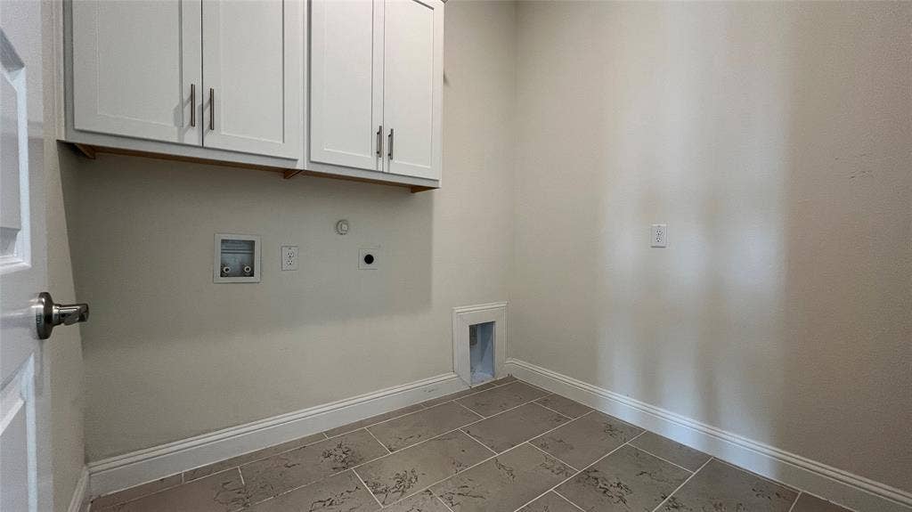 333 Elk Drive, Fate, TX 75189 Utility room featuring white shaker-style wall cabinets with brushed nickel hardware, neutral-toned tile flooring, and dedicated hookups for laundry appliances