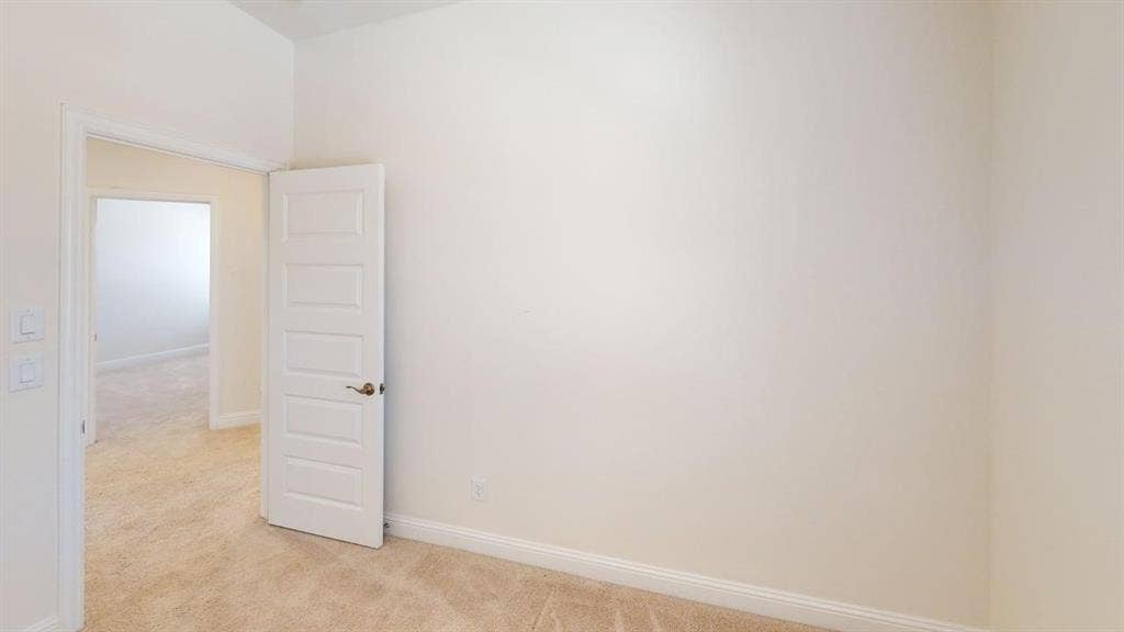 333 Elk Drive, Fate, TX 75189 Neutral wall tones, carpeting, and five-panel interior door with brushed metal hardware