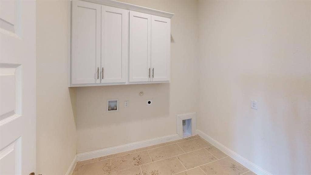 333 Elk Drive, Fate, TX 75189 Utility space featuring white shaker-style wall cabinetry with brushed nickel hardware and neutral tile flooring