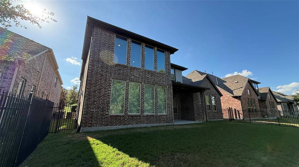 7005 Golf Club Drive, McKinney, TX 75070 Two-story brick exterior featuring a covered patio, extensive dual-level windows, and fenced backyard