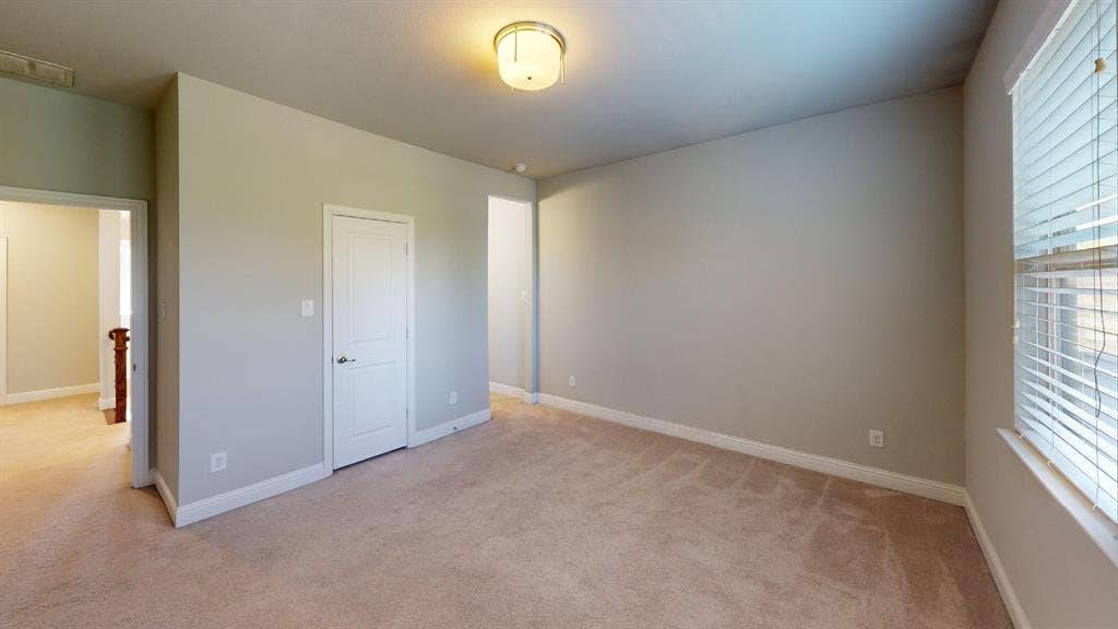 7005 Golf Club Drive, McKinney, TX 75070 Neutral-toned interior space featuring wall-to-wall carpeting, a multi-panel door, and a flush-mount drum light fixture