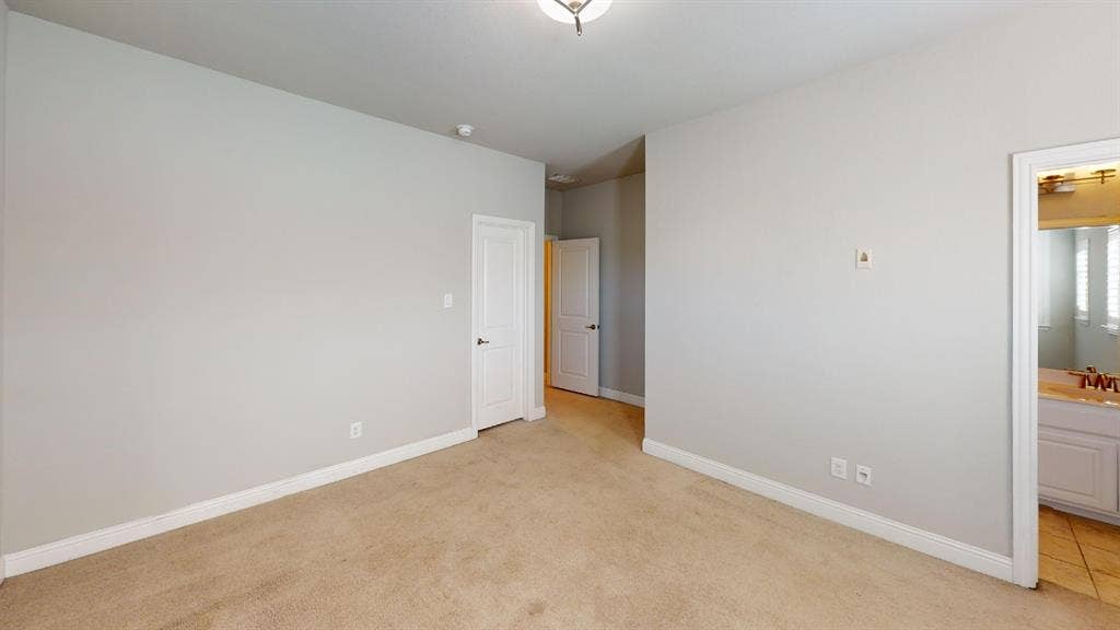 7005 Golf Club Drive, McKinney, TX 75070 Interior room featuring neutral wall paint, wall-to-wall carpeting, two interior panel doors, and a ceiling-mounted light fixture