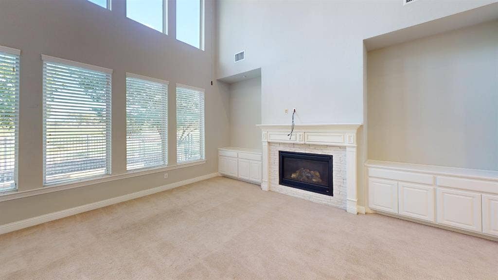 7005 Golf Club Drive, McKinney, TX 75070 High ceilings with tiered windows, fireplace with a painted brick surround, and white built-in cabinetry