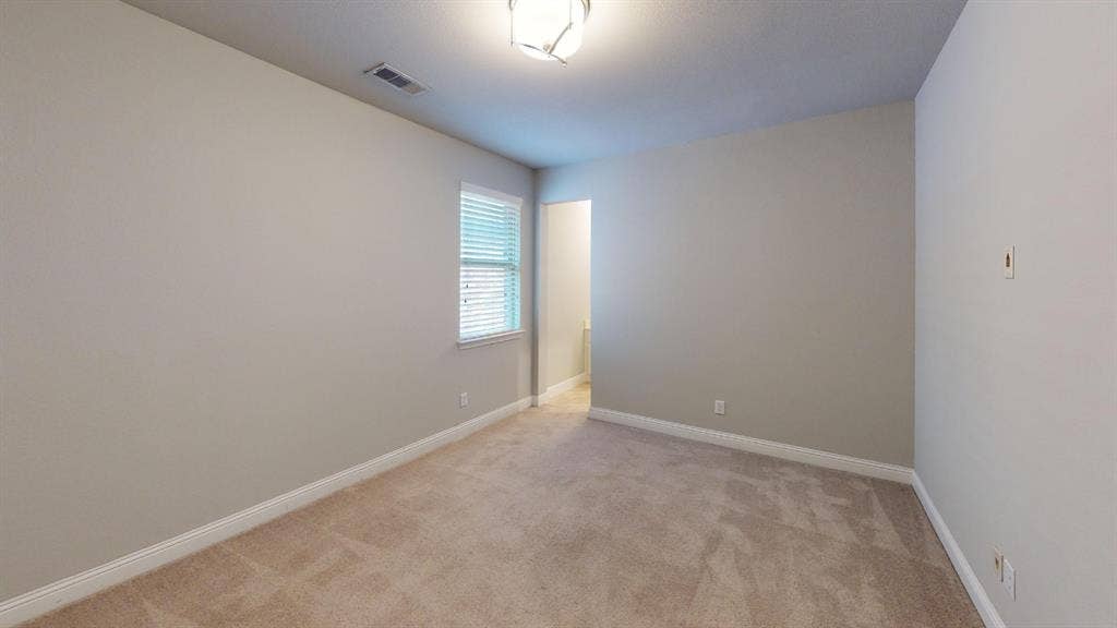 7005 Golf Club Drive, McKinney, TX 75070 Neutral wall tones, wall-to-wall carpeting, single-pane window with horizontal blinds, and a central overhead flush-mount light fixture