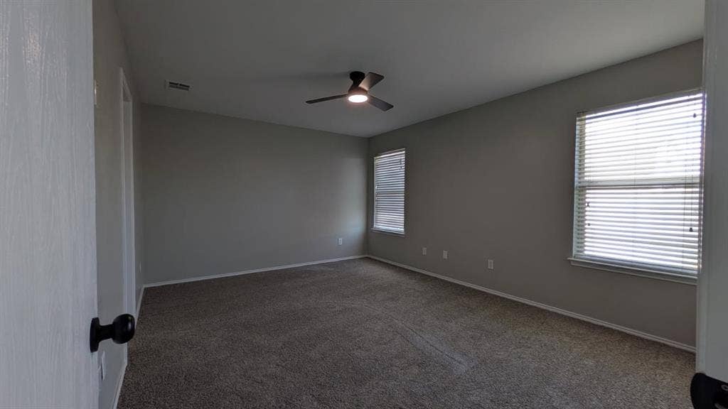 408 Oxford Loop Loop, Princeton, TX 75407 Neutral-toned walls, wall-to-wall carpeting, dual windows with horizontal blinds, and a central ceiling fan with integrated lighting