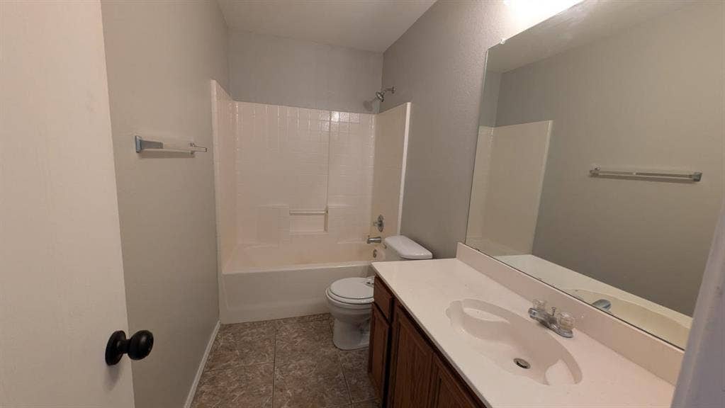 408 Oxford Loop Loop, Princeton, TX 75407 Bathroom featuring a vanity with a white countertop and integrated sink, full-width mirror, tile flooring, and a tub-shower combination with tiled surround