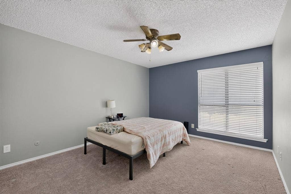5750 Phoenix Drive, #6, Dallas, TX 75231 Spacious room featuring carpeting, a prominent window with blinds, and a ceiling fan with integrated lighting