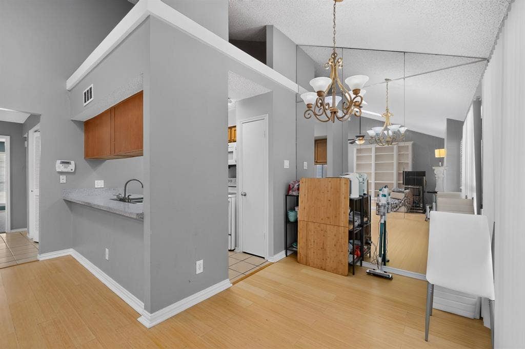 5750 Phoenix Drive, #6, Dallas, TX 75231 Wood-finish flooring throughout, complemented by a vaulted ceiling and a decorative chandelier