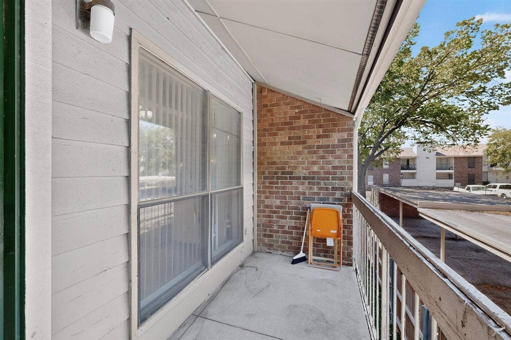 5750 Phoenix Drive, #6, Dallas, TX 75231 Private balcony featuring concrete flooring, brick and siding exterior, and a white railing