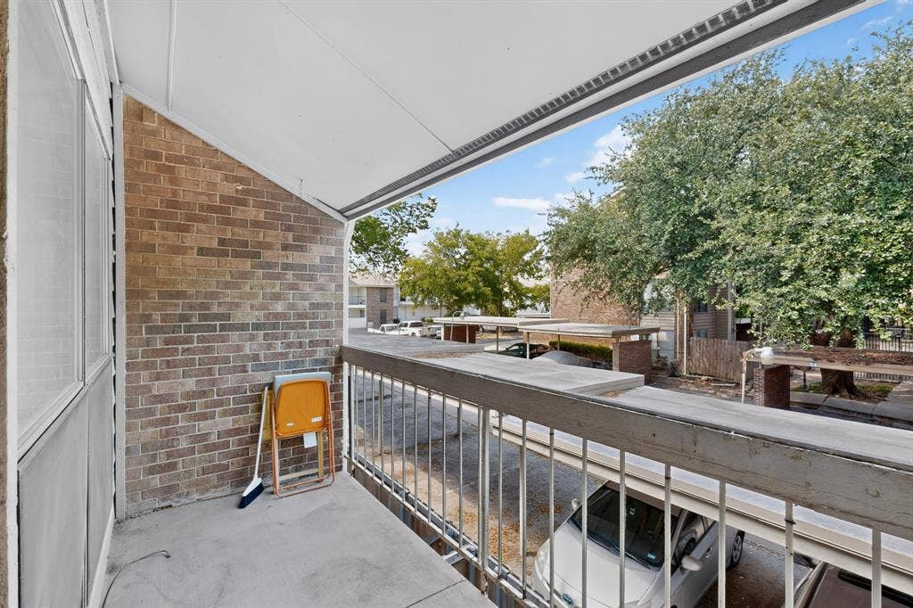 5750 Phoenix Drive, #6, Dallas, TX 75231 Covered outdoor balcony with concrete flooring, brick wall, and metal railing