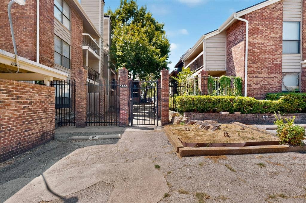 5750 Phoenix Drive, #6, Dallas, TX 75231 Brick exterior construction with an ornamental wrought-iron pedestrian gate and vehicular gate